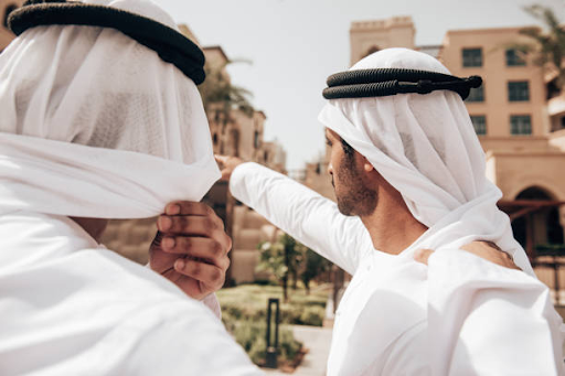 Two men in traditional attire discussing and pointing towards a key area in a strategic location.